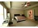 Large bedroom with ceiling fan, desk, and view of the bathroom via double doors at 560 Tuscany Walk Ln, Lawrenceville, GA 30043