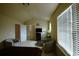 Comfortable bedroom featuring sitting area, bed, and large window with blinds at 560 Tuscany Walk Ln, Lawrenceville, GA 30043