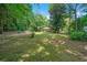 Expansive backyard featuring lush greenery, mature trees, and a partial view of the residence at 57 Jonathan Rd, Riverdale, GA 30274