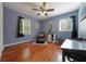 Bedroom with hardwood floors, two windows, and a ceiling fan at 57 Jonathan Rd, Riverdale, GA 30274