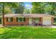 Charming brick ranch-style home featuring a well-manicured lawn and an attached one car garage at 57 Jonathan Rd, Riverdale, GA 30274