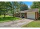 Well-maintained brick home with a green lawn, mature trees, and attached one car garage at 57 Jonathan Rd, Riverdale, GA 30274