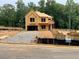 Exterior view of a home under construction shows exposed framing on a large lot with construction containers at 731 Crest Line Trl, Powder Springs, GA 30127