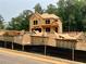 Exterior view of a home under construction shows exposed framing on a large lot with construction containers at 731 Crest Line Trl, Powder Springs, GA 30127