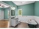 Stylish bathroom featuring a clawfoot tub, wainscoting, and vanity with sink at 2058 Sewanee Ct, Villa Rica, GA 30180
