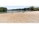Wide sandy beach with picnic tables and lifeguard stands overlooking the serene lake and wooded shoreline at 2058 Sewanee Ct, Villa Rica, GA 30180