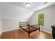 Attic bedroom with hardwood floors, angled ceiling and bed frame; nice window view at 2058 Sewanee Ct, Villa Rica, GA 30180