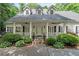 Inviting front porch with elegant columns and a beautifully landscaped garden at 2058 Sewanee Ct, Villa Rica, GA 30180