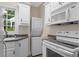 Efficient laundry area with stacked washer and dryer, plus white cabinets and sink at 2058 Sewanee Ct, Villa Rica, GA 30180