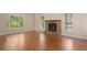 Spacious living room featuring hardwood floors, fireplace, and ample natural light from two windows at 2058 Sewanee Ct, Villa Rica, GA 30180