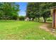 Large, grassy backyard featuring a storage shed surrounded by mature trees and lush greenery at 2135 Knighton Dr, Atlanta, GA 30349