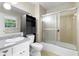 Bathroom featuring a shower and tub with sliding glass doors and vanity with a white sink and granite countertop at 2135 Knighton Dr, Atlanta, GA 30349