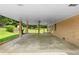View of covered carport with a brick wall, flat concrete, and surrounding greenery at 2135 Knighton Dr, Atlanta, GA 30349