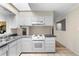 Kitchen featuring white cabinetry and a view to the adjacent sun room and dining area at 2135 Knighton Dr, Atlanta, GA 30349