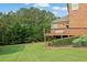 Exterior view of the backyard featuring a large deck overlooking the manicured lawn and greenery at 2450 Weber Heights Way, Buford, GA 30519