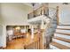 Open foyer features hardwood floors, staircase with iron spindles, and view of living spaces at 2450 Weber Heights Way, Buford, GA 30519
