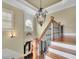 Elegant foyer featuring a staircase with hardwood and decorative black iron spindles at 2450 Weber Heights Way, Buford, GA 30519