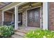 Close-up of the ornate front door and stone entryway, featuring elegant detailing and manicured greenery at 2450 Weber Heights Way, Buford, GA 30519