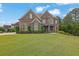 Charming brick home featuring manicured lawn, stone accents, and a meticulously landscaped front yard at 2450 Weber Heights Way, Buford, GA 30519