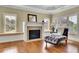 Cozy living room with hardwood floors, fireplace, and sunny windows with plantation shutters at 2450 Weber Heights Way, Buford, GA 30519