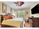 Spacious main bedroom with decorative ceiling fan, window with shutters, and flatscreen television at 2450 Weber Heights Way, Buford, GA 30519