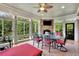 Relaxing sunroom with brick fireplace, tile floors, and expansive windows overlooking backyard at 2450 Weber Heights Way, Buford, GA 30519
