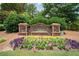 Landscaped entrance sign for Suwanee Creek Park with colorful flowers and American flags at 4434 Austin Hills Dr, Suwanee, GA 30024