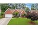 Charming red brick home with a well-manicured lawn, a two-car garage, and a welcoming blue front door at 4434 Austin Hills Dr, Suwanee, GA 30024