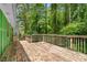 An inviting wooden back deck with railings surrounded by lush greenery at 5760 Windermere Ct, Lithonia, GA 30038