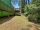 The backyard has a blend of grass and natural growth beneath an elevated deck at 5760 Windermere Ct, Lithonia, GA 30038