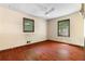 Bright bedroom featuring hardwood floors, a ceiling fan and two windows at 5760 Windermere Ct, Lithonia, GA 30038
