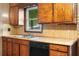 Traditional kitchen featuring wooden cabinets, laminate countertops, double sink and black dishwasher at 5760 Windermere Ct, Lithonia, GA 30038