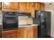 Traditional eat-in kitchen featuring wooden cabinetry, laminate countertops, and black appliances at 5760 Windermere Ct, Lithonia, GA 30038
