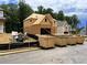 View of a house under construction with exposed framing alongside several large waste disposal containers at 727 Crest Line Trl, Powder Springs, GA 30127
