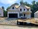 Two-story new construction home with a two-car garage and covered front porch, under construction at 727 Crest Line Trl, Powder Springs, GA 30127