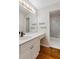 Bathroom with white vanity, large mirror, and a shower-tub combo with glass doors at 912 Chipley Ct, Marietta, GA 30062
