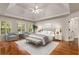 Bright bedroom boasts a tray ceiling, hardwood floors, and cozy seating area by the windows at 912 Chipley Ct, Marietta, GA 30062