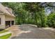 Expansive paved driveway leading to a three-car garage, surrounded by mature trees and landscaping for added privacy at 912 Chipley Ct, Marietta, GA 30062