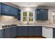Charming kitchen features blue cabinets, granite countertops, a window, and stainless-steel appliances at 912 Chipley Ct, Marietta, GA 30062