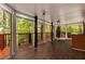Sunroom with hardwood flooring, multiple windows offering an unobstructed view of the surrounding forest and a red deck at 912 Chipley Ct, Marietta, GA 30062
