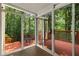 Sunroom with hardwood flooring, sliding glass doors that lead to a red deck, and unobstructed forest views at 912 Chipley Ct, Marietta, GA 30062