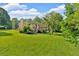 Landscaped backyard view of the home with mature trees, plants, and a deck at 19 Quail Hollow Ct, Dallas, GA 30157
