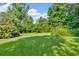Expansive backyard featuring lush green grass, trees, and shrubbery at 19 Quail Hollow Ct, Dallas, GA 30157