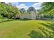 Wide angle backyard view of home with lush green grass, trees, and landscaping at 19 Quail Hollow Ct, Dallas, GA 30157