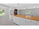 Open kitchen featuring white cabinets, butcher block countertops and a fireplace at 19 Quail Hollow Ct, Dallas, GA 30157