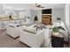 Bright, open living room featuring stone fireplace, ceiling fan, and adjacent kitchen with barstool seating at 19 Quail Hollow Ct, Dallas, GA 30157