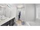 Bathroom featuring a dual sink vanity, walk-in shower, and large soaking tub at 2013 Chesley Dr, Austell, GA 30106
