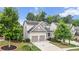 View of home showcasing two-car garage, tidy lawn and landscaping, in a tree-filled neighborhood at 2013 Chesley Dr, Austell, GA 30106
