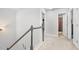 Upstairs hallway with neutral carpet, trimmed railings and access to bedrooms and bathrooms at 2013 Chesley Dr, Austell, GA 30106