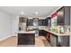 Well-lit kitchen with stainless steel appliances, granite counters, and dark cabinetry at 2013 Chesley Dr, Austell, GA 30106